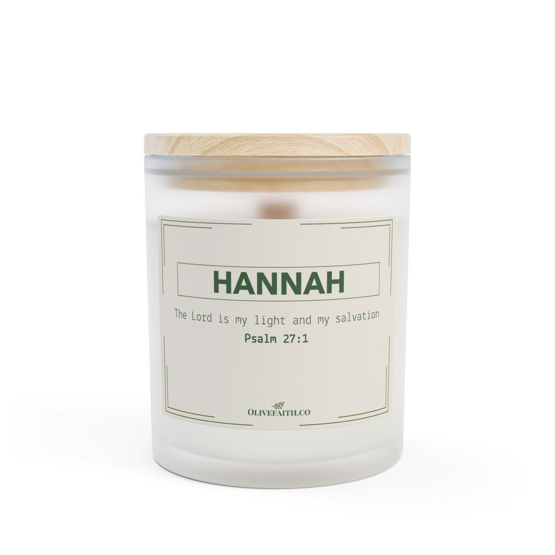 personalized frosted glass candle with a wooden lid, labeled “HANNAH” and “The Lord is my light and my salvation – Psalm 27:1” in soft green font, placed on a marble countertop with a blurred background of beige curtains and a vase with greenery, in a gentle, neutral lifestyle setting – Olive Faith Christian gift.