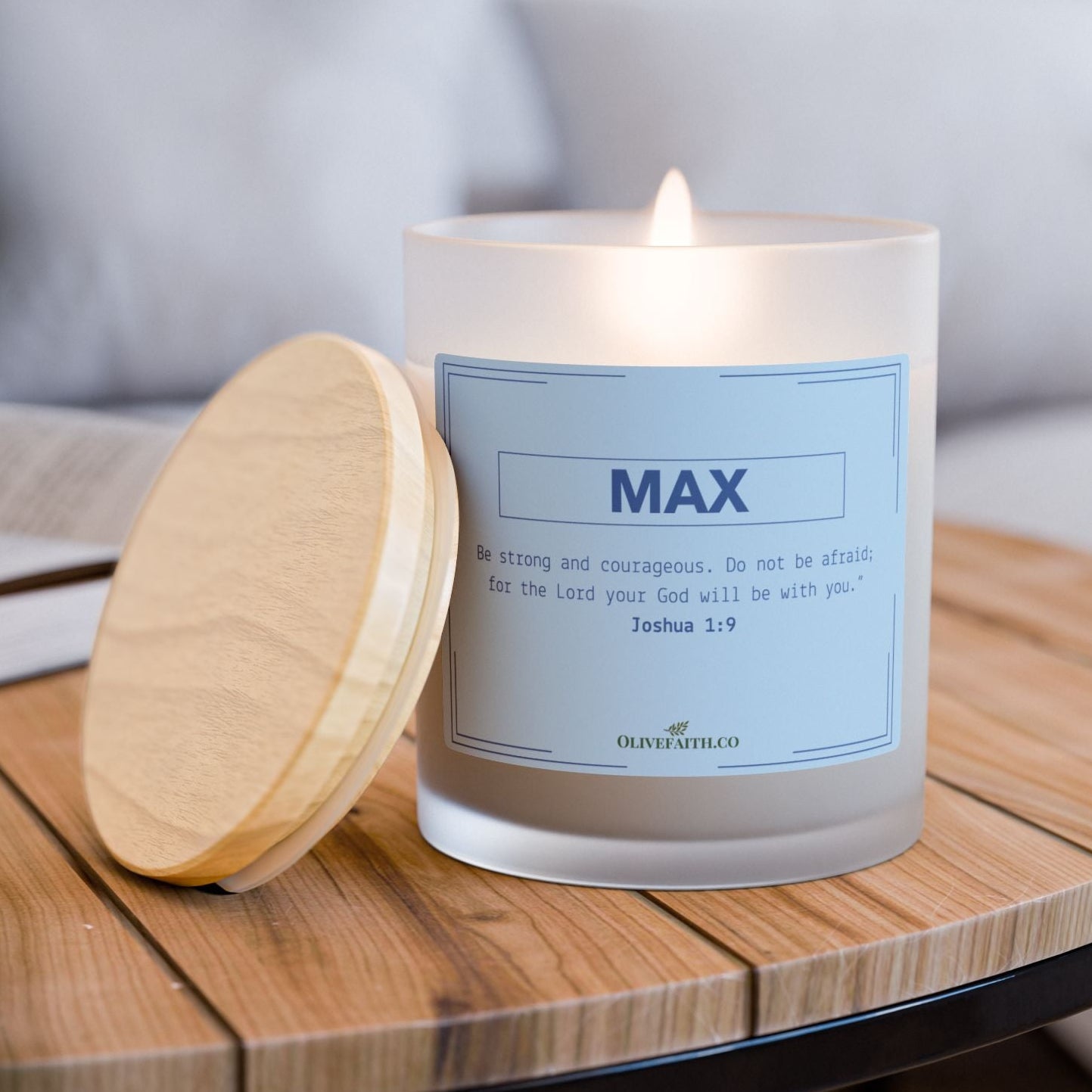 personalized 11oz frosted glass candle with wooden lid, labeled with the name and the verse “Be strong and courageous. Do not be afraid; for the Lord your God will be with you – Joshua 1:9” in a soft blue-grey style, set in a calming, minimal home setting – Olive Faith Christian gift.
