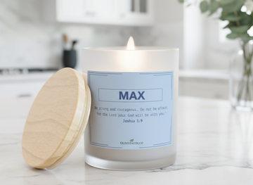 “Be strong and courageous personalized Christian candle. Do not be afraid; for the Lord your God will be with you. – Joshua 1:9” in soft blue font, displayed on a marble countertop in a bright, modern kitchen with greenery and natural daylight – Christian gift by Olive Faith.